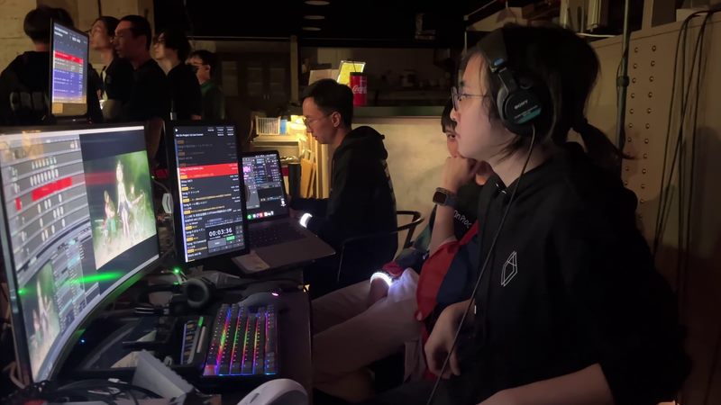 Production team operating monitors and control software during a live event