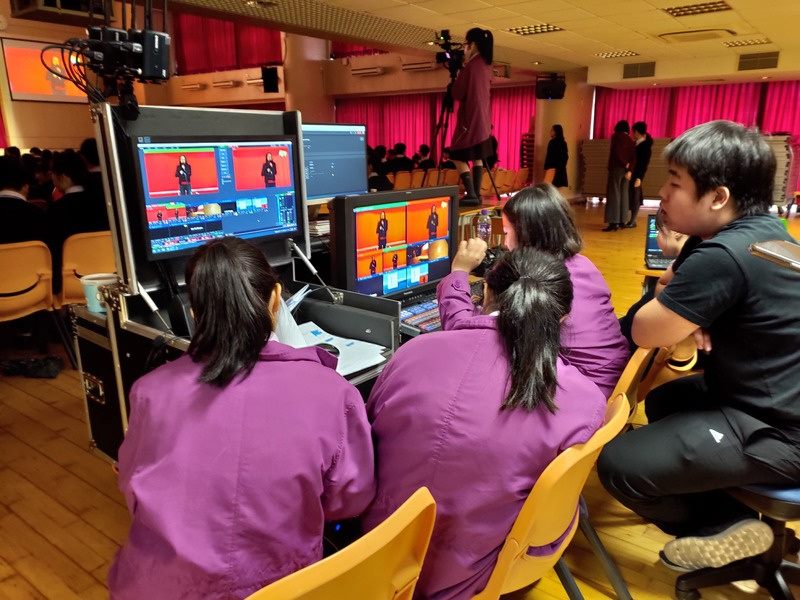 Students operating a multicamera broadcast setup during a school event